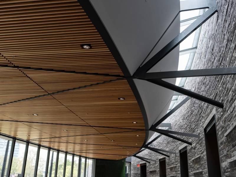 La sala principal del nuevo pabellón del Centro Davis en el norte de Central Park, con muros de granito y cerchas de acero.