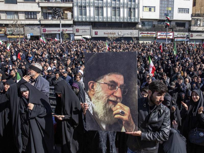 A man holds a portrait of Iran’s Supreme Leader Ayatollah Ali Khamenei as people mourn his killing at a rally in Tehran, Iran, on Sunday, March 1, 2026, a day after he was killed in coordinated U.S. and Israeli airstrikes. A badly weakened Iran will no longer intimidate or threaten its neighbors in the same way, and the regional impact could be comparable to the collapse of the Soviet Union. (Arash Khamooshi/The New York Times)