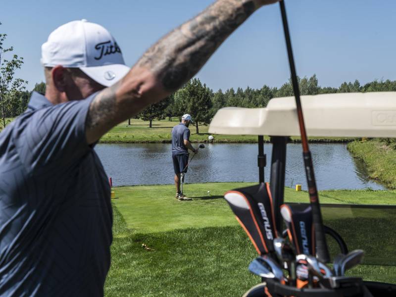 Anatoly Melnychenko (izq.) y Oleksandr Batalov, ambos amputados de guerra, en el campo de golf de Kozyn.
