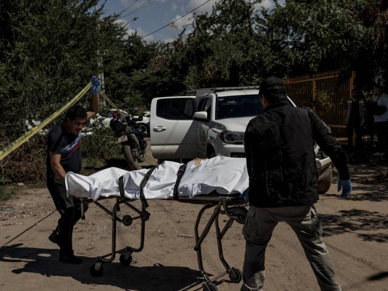 Un trabajador funerario (izq.) ayuda a recuperar un cuerpo en las afueras de la ciudad de Culiacán, México.