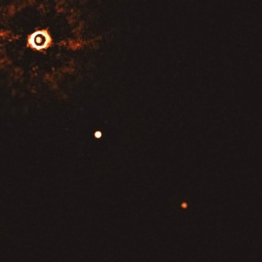 Esta imagen distribuida por el Observatorio Europeo Austral en julio de 2020 muestra la estrella TYC 8998-760-1, superior izquierda, y dos exoplanetas gigantes. El sistema se encuentra a 300 años luz de la Tierra. (Bohn et al./OEA via AP)