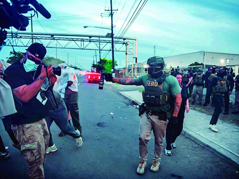 Migración. Un agente del ICE lanza gas lacrimógeno contra manifestantes y periodistas durante una protesta ayer miércoles contra el trato a los detenidos en el centro de detención de Delaney en Newark, Nueva Jersey.