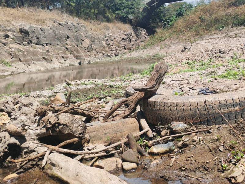 Entre el lodo seco y el pequeño hilo de agua que todavía corre por el Guacerique aparecen residuos que revelan la contaminación del cauce.