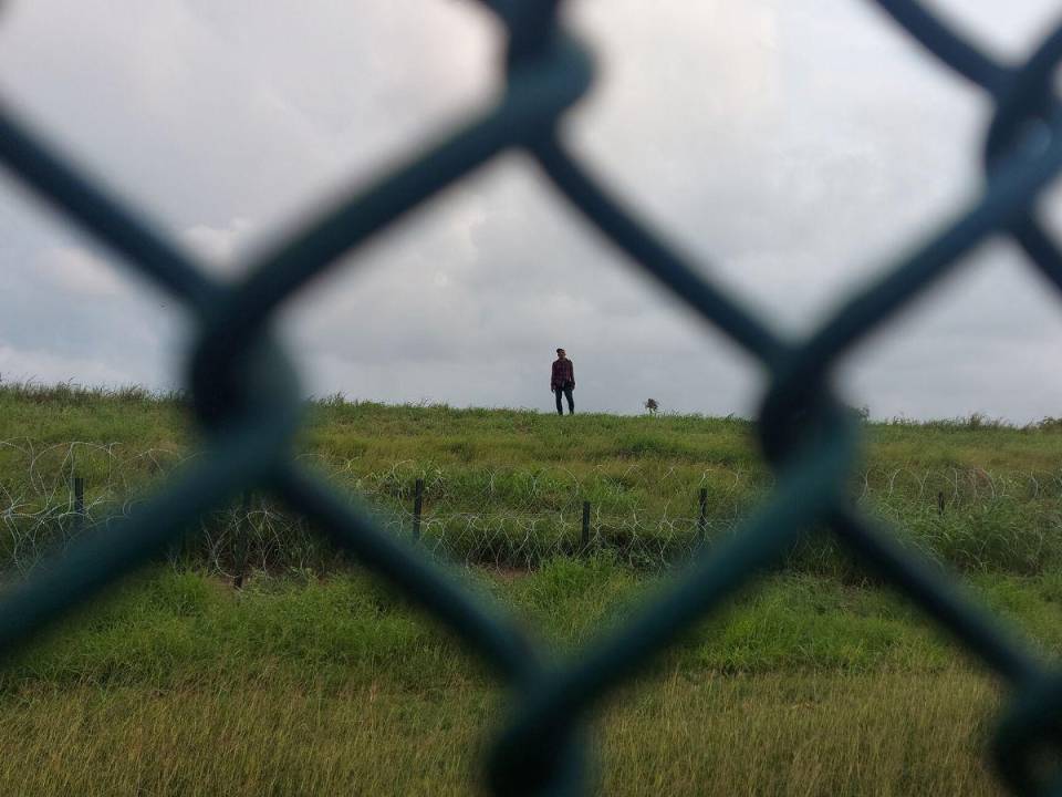 Jimmy Muñoz, un ecuatoriano de 29 años, logró entrar pero tiene frente a él un alambrado de púas y la valla de unos 4 metros de alto.