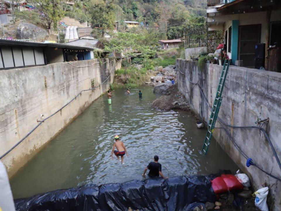 Los pobladores de San Juancito han formado una poza en el río que cruza en el centro de la aldea, grandes y pequeños se refrescan en esta agua que baja de la montaña.