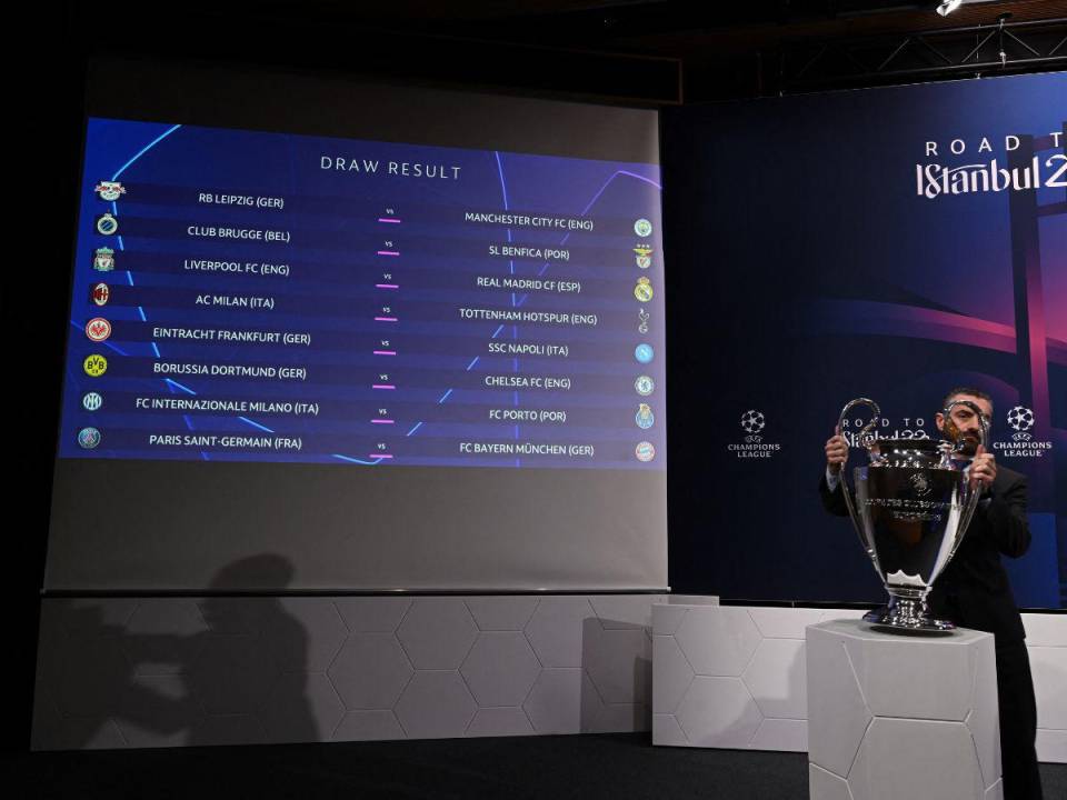 n hombre retira el trofeo de la UEFA Champions League frente a una pantalla que muestra el resultado del sorteo de los octavos de final del torneo de fútbol de la UEFA Champions League 2022-2023 en Nyon el 7 de noviembre de 2022.
