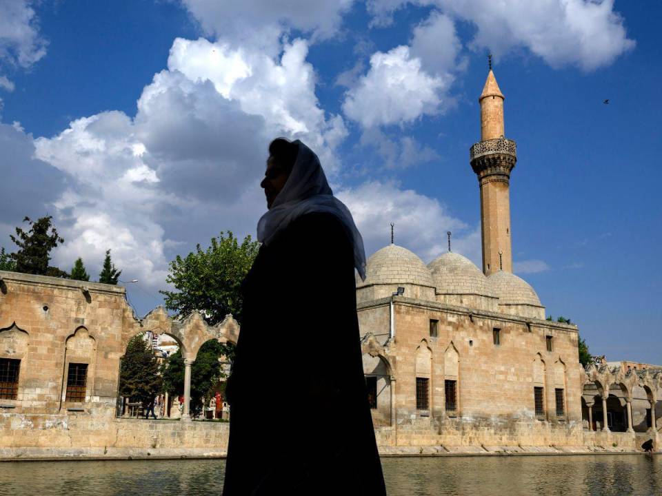 Una mujer camina cerca de Balikligol (o Piscina de Abraham, lago Halil-Ur Rahman) en Sanliurfa, sureste de Turquía.