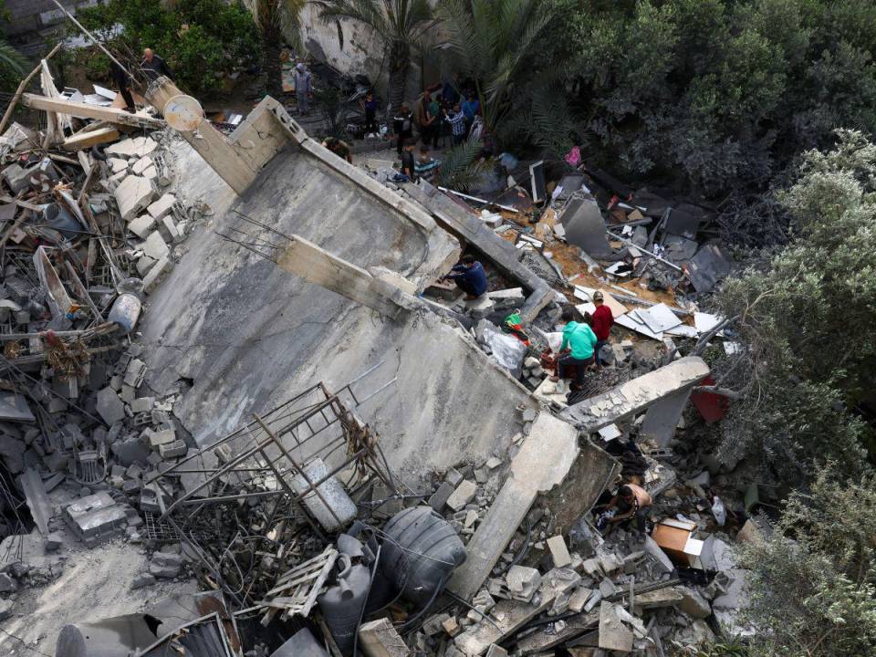 Los palestinos inspeccionan los escombros de un edificio, luego de un ataque aéreo israelí, en Beit Lahia, en el norte de la Franja de Gaza.