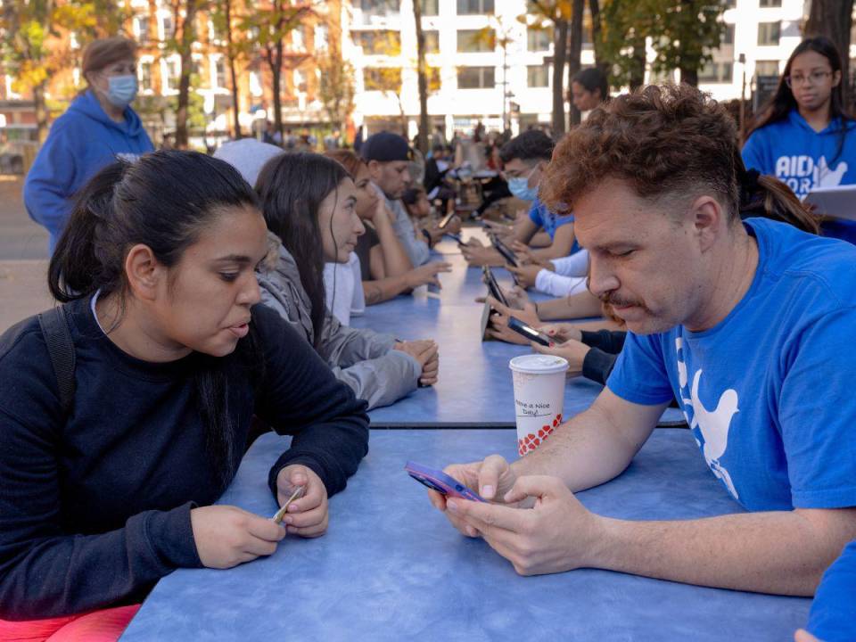 Migrantes recién llegados se reúnen con voluntarios en un centro de bienvenida en el Lower East Side.