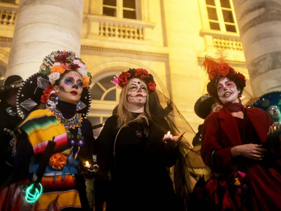 Mujeres con trajes típicos asisten al desfile durante el Día de Muertos con una procesión de “Catrinas”