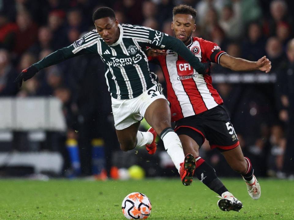 El delantero francés del Manchester United #09 Anthony Martial (L) compite con el defensor estadounidense del Sheffield United #05 Auston Trusty (R) durante el partido de fútbol de la Premier League inglesa entre Sheffield United y Manchester United en Bramall Lane en Sheffield, norte de Inglaterra, el 21 de octubre de 2023.