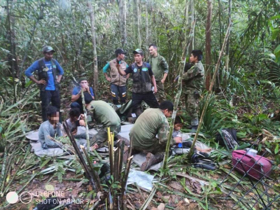 En esta foto del folleto publicada el 9 de junio de 2023 por la Presidencia de Colombia, miembros del ejército atienden a cuatro niños indígenas que fueron encontrados con vida después de pasar más de un mes perdidos en la selva amazónica colombiana tras el accidente de una avioneta.