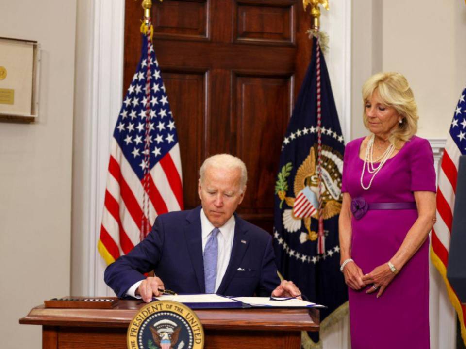 Momento en que el presidente Biden firmó la ley para regular las armas de fuego.