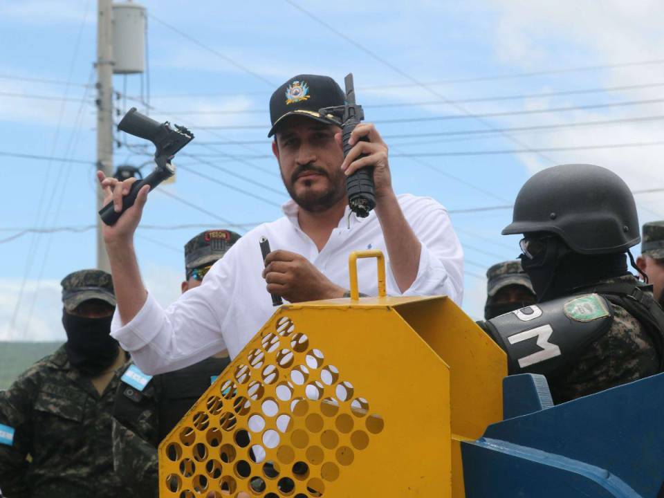 El ministro José Manuel Zelaya Rosales muestra los pedazos de un AR-15 después de ser destruido con una guillotina.