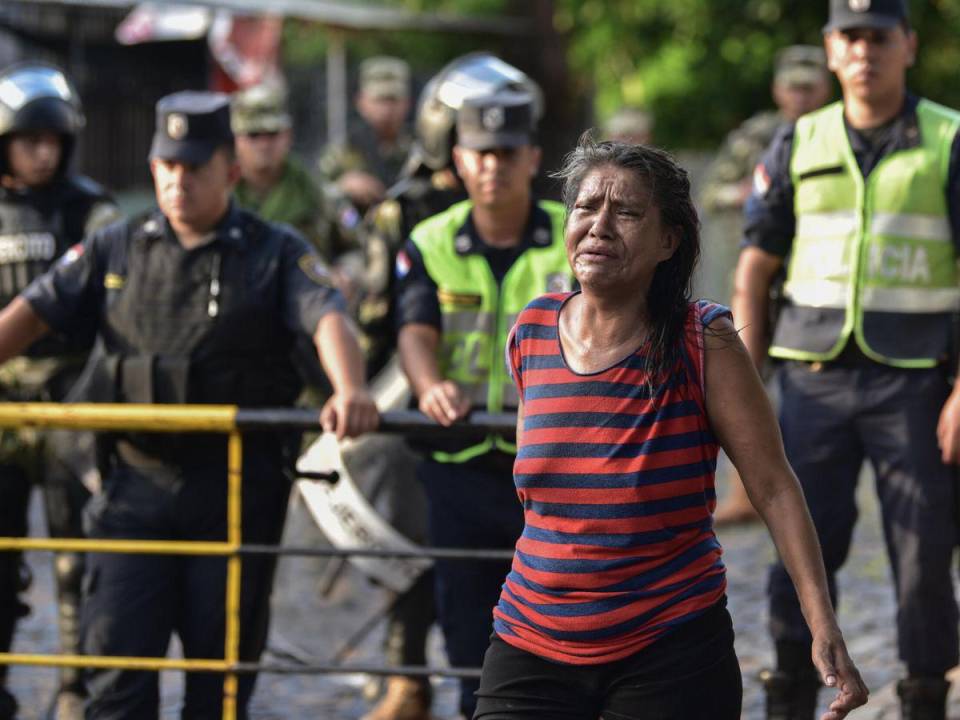 Familiar de un preso protesta cuando la policía transportaba a detenidos de la cárcel de Tacumbú en Asunción hacia otros centros penales, este lunes 18 de diciembre de 2023.