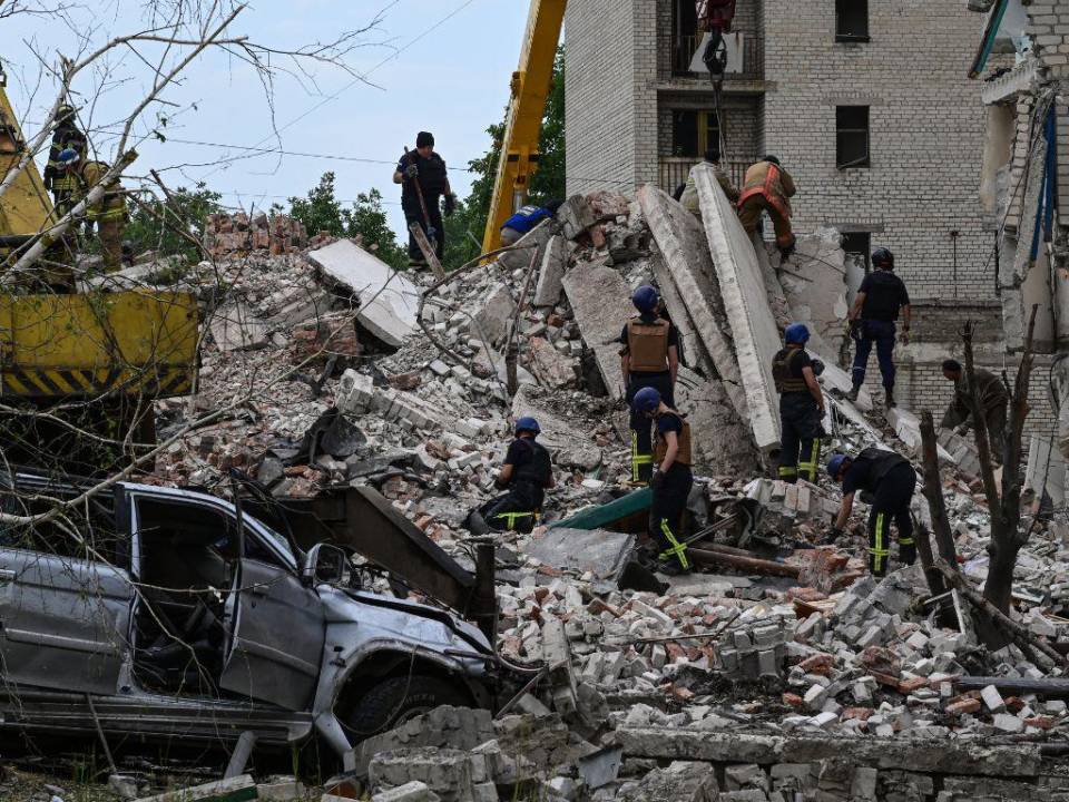 Los rescatistas despejan la escena después de que un edificio fuera parcialmente destruido como resultado del impacto de un misil ruso en un edificio residencial de cuatro pisos en Chasiv Yar, distrito de Bakhmut, este de Ucrania, el 10 de julio de 2022. Al menos seis personas murieron y otras cinco fueron resultó herido en un ataque ruso a un edificio de apartamentos en la ciudad de Chasiv Yar, dijo un funcionario local.