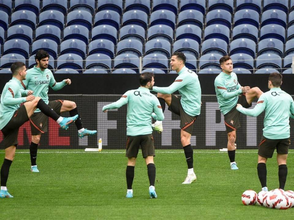 El entrenador de Portugal, Fernando Santos (D), observa cómo sus jugadores asisten a una sesión de entrenamiento en el Estadio Dragao en Oporto, el 23 de marzo de 2022, en la víspera de su partido de clasificación para la Copa Mundial de la FIFA contra Turquía.