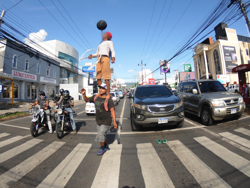 María, una pequeña niña de once años realiza un acto callejero en uno de los semáforos del bulevar Morazán