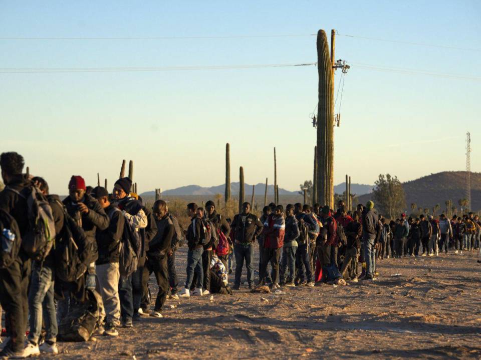 Migrantes esperan a ser procesados por agentes de la Patrulla Fronteriza de EU en Lukeville, Arizona.