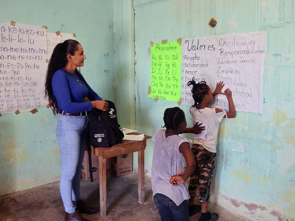 Con un pizarrón a base de papel les enseña el abecedario y sus quehaceres académicas a los niños que buscan el pan del saber en la escuela inaugurada por la hondureña Mayuri Ramírez.