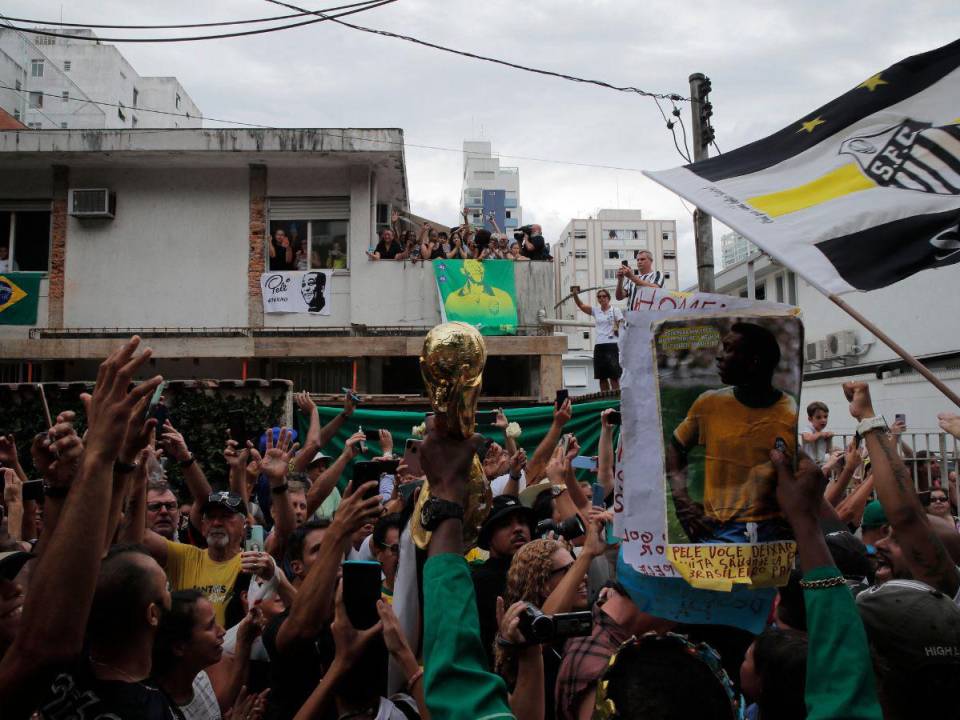 Los fanáticos de la difunta estrella del fútbol brasileño Pelé se reúnen en la calle mientras un camión de bomberos transporta el ataúd de Pelé al Cementerio Conmemorativo de Santos en Santos, estado de Sao Paulo, Brasil el 3 de enero de 2023. La procesión fúnebre a través de Santos pasará por la casa de Pelé madre, Celeste Arantes, de 100 años, que aún vive. Terminará en el Cementerio Conmemorativo de Santos, donde se llevará a cabo un funeral católico antes de que Pele sea enterrado en un mausoleo especial.