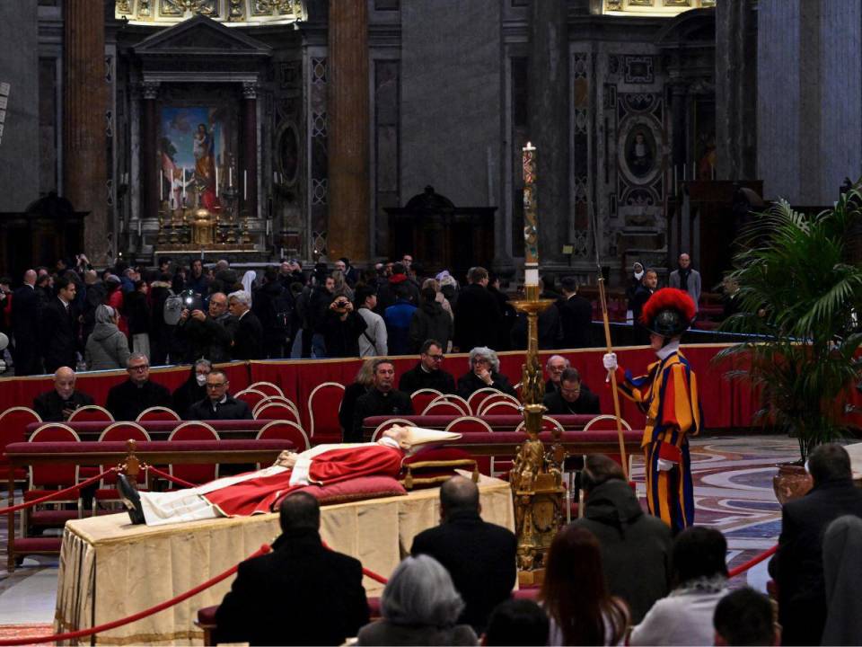 Los fieles entran en silencio por el pasillo central del templo católico más grande del mundo, la mayoría fotografiando con sus móviles el cuerpo del ex papa.