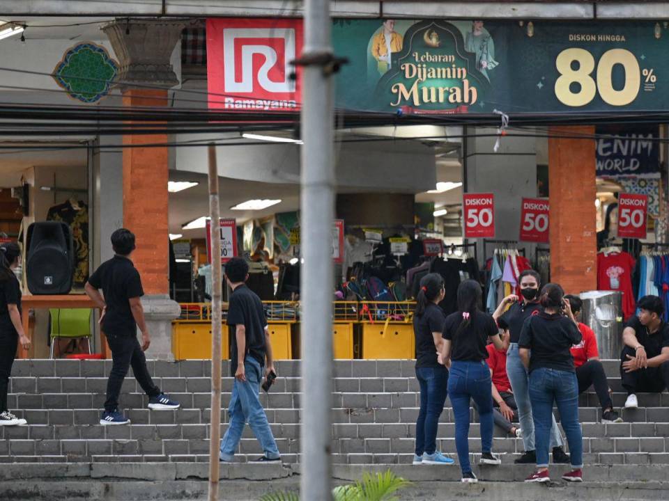 Los empleados de una tienda esperan afuera del edificio en Denpasar, en la isla turística de Bali, luego de que se registrara el terremoto de magnitud 7.0 en el mar al norte de la principal isla indonesia de Java.