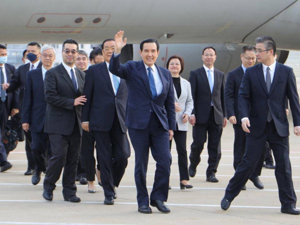 En esta foto del folleto tomada y publicada en la oficina del expresidente Ma Ying-jeou el 27 de marzo de 2023, el expresidente taiwanés Ma Ying-jeou (centro) saluda al llegar al aeropuerto de Shanghái.