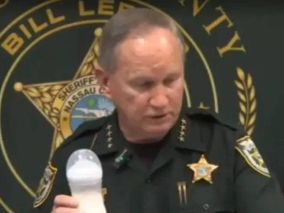 El sheriff Bill Leeper, sostiene en su mano un biberón mientras explica el horrendo caso.