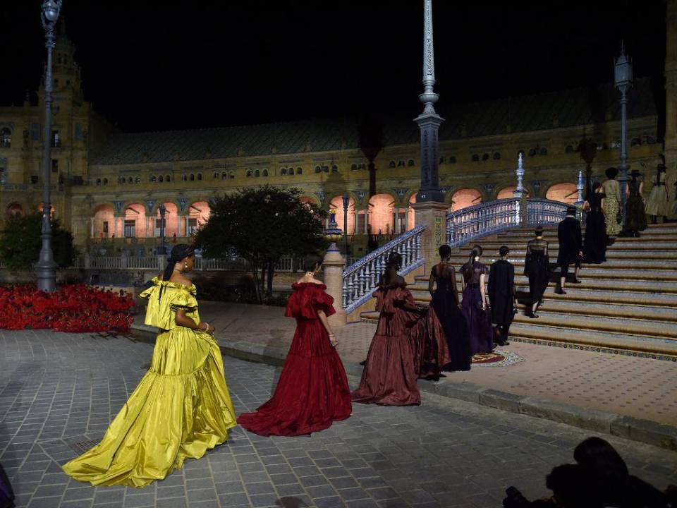 Las modelos presentan las creaciones de alta costura durante el desfile de moda de Dior en la Plaza de España de Sevilla.