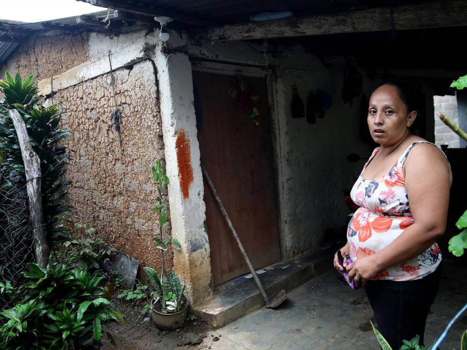 Lesly Flores vive en Las Lajas, Comayagua. Al fondo se ve la casa que abandonó en 2023 porque los sismos provocaron que las paredes se dañaran; en este 2025 volvió a ocuparla porque no tenía dónde vivir.